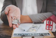 Pros and cons of owner financing salesperson holding house keys concept