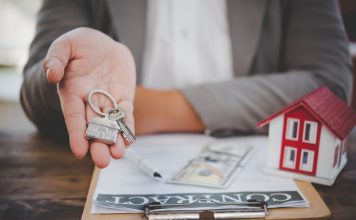 Pros and cons of owner financing salesperson holding house keys concept